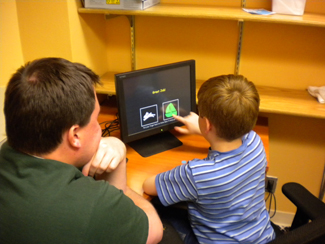 Staff member and child doing an activity on a computer