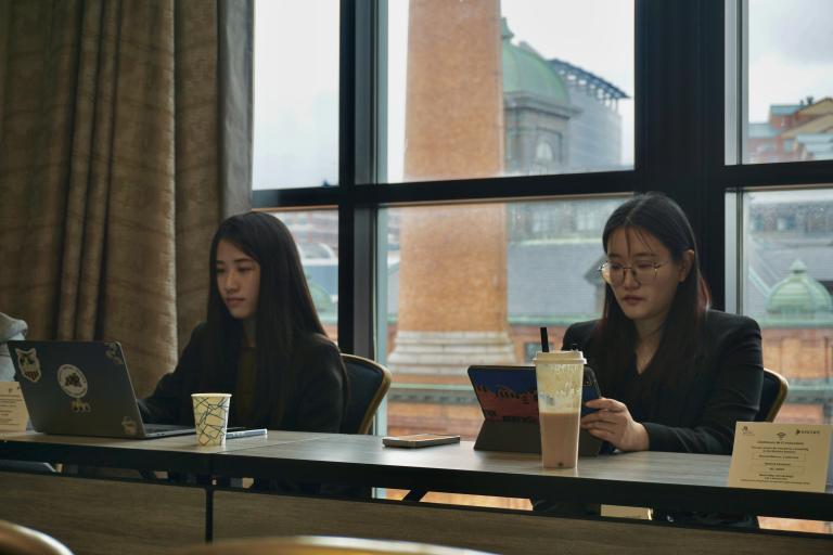 Lab members Sijin Chen (left) and Yunqi Wang (right) seated as presenters during a paper session at the NCFR conference.